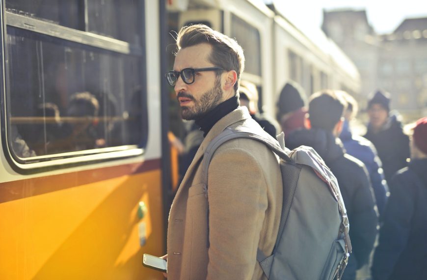 man-in-brown-coat-and-gray-backpack-posing-for-a-photo